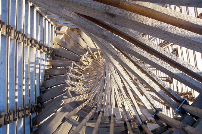 Designed by Hut architektury in 2006, Scholzberg Tower is a wooden hand-built double helix staircase, offering great views of the Czech countryside. The circular rotation of the staircase slightly sticks out of the structure's sides. 