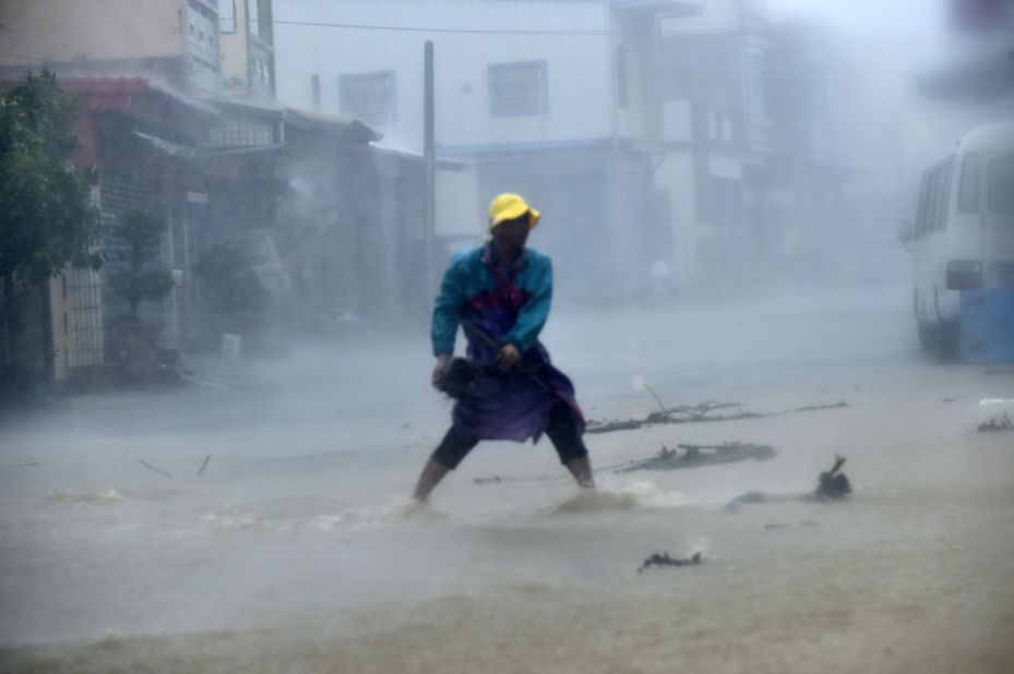 A local resident removes a rock from a blocked road in Pingtung county in southern Taiwan.