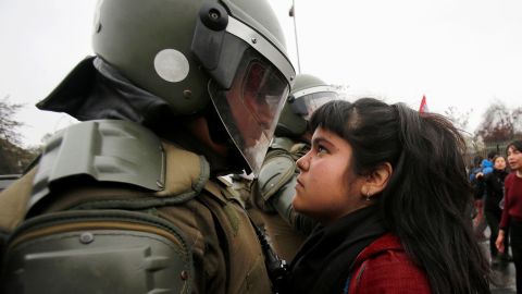 The young demonstrator locked eyes with a riot policeman during a pro democracy protest in Santiago, Chile 