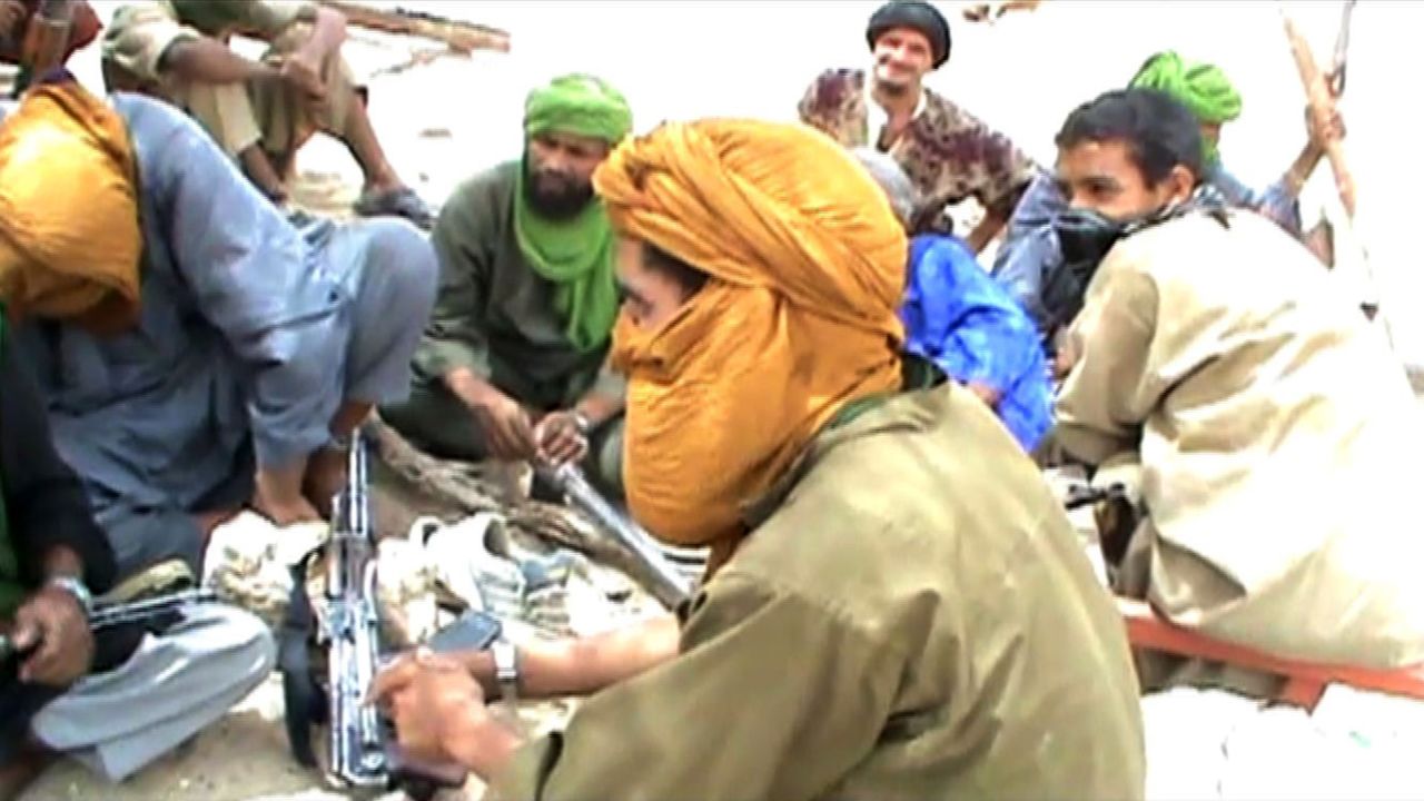 A still from a video shows Islamist militants sitting on the ground with their weapons after destroying an ancient shrine in Timbuktu on July 1, 2012. Islamist rebels in northern Mali smashed four more tombs of ancient Muslim saints in Timbuktu on July 1 as the International Criminal Court warned their campaign of destruction was a war crime.  The hardline Islamists who seized control of Timbuktu along with the rest of northern Mali three months ago, consider the shrines to be idolatrous and have wrecked seven tombs in two days.    AFP PHOTO        (Photo credit should read STR/AFP/GettyImages)