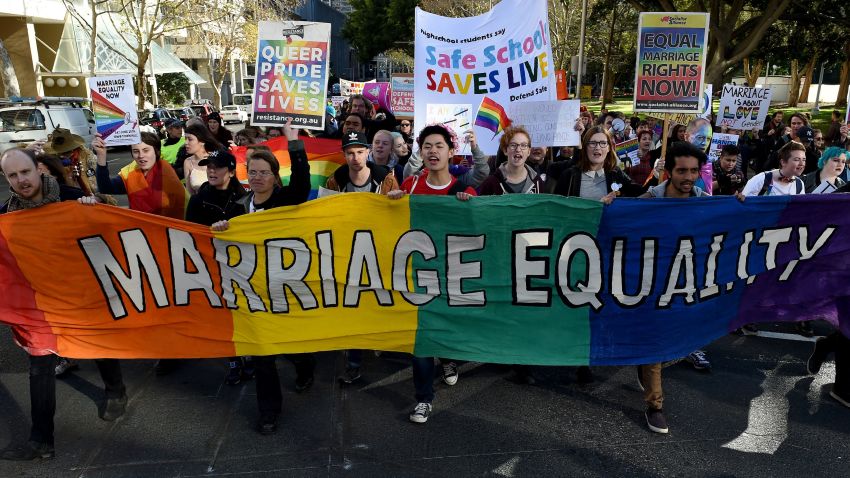 Pro-gay marriage supporters carry a rainbow banner and flags during a rally in Sydney on June 25, 2016.
Hundreds of supporters of gay marriage marched through the streets of the central business district of Sydney for their rights. / AFP / SAEED KHAN        (Photo credit should read SAEED KHAN/AFP/Getty Images)