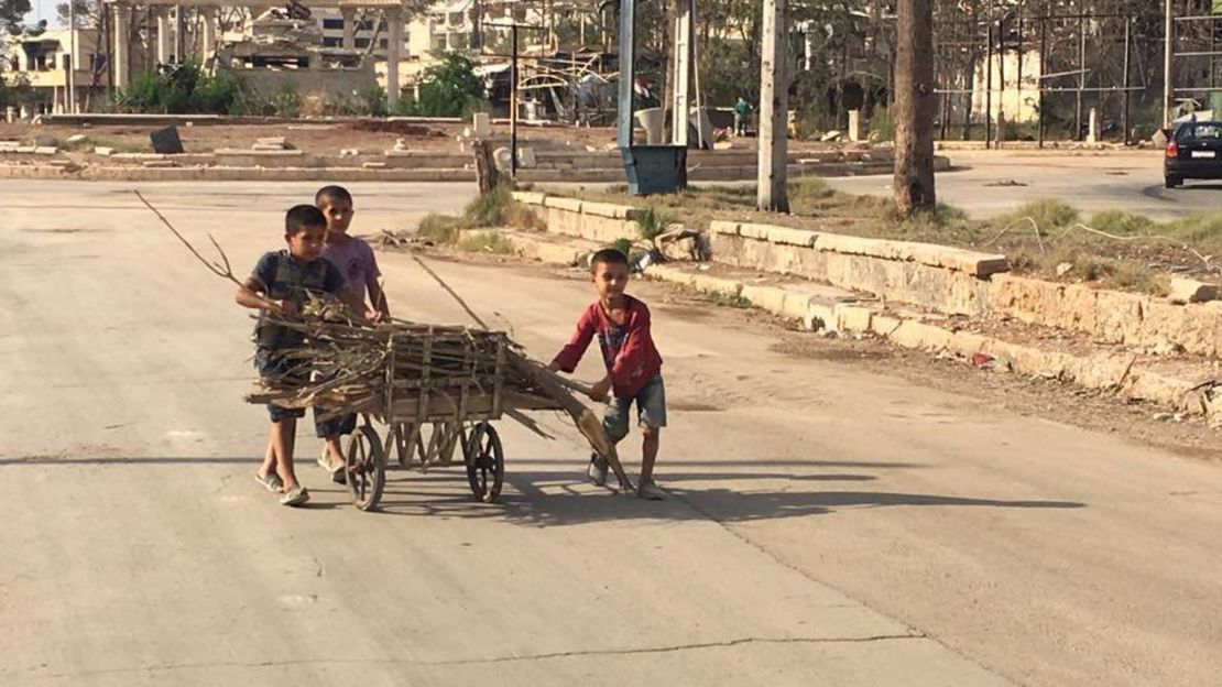 Children push a cart loaded with firewood collected in an Aleppo neighborhood.