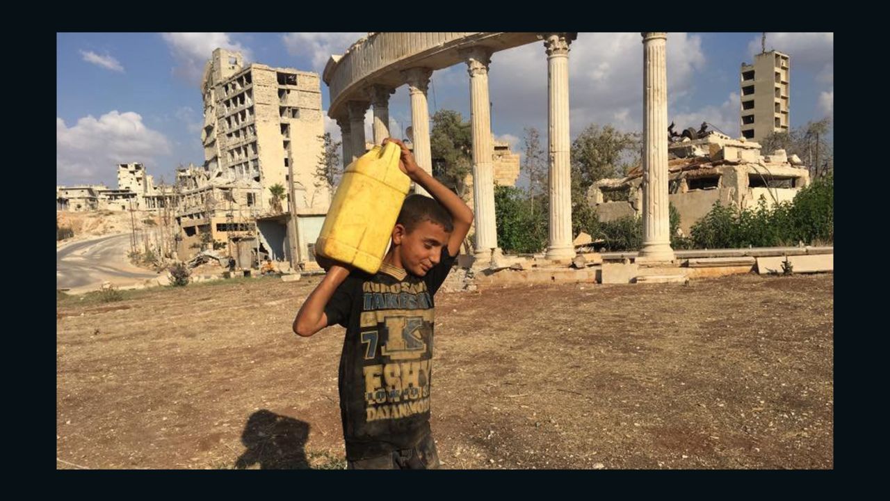 A child carries a canister filled with water near Aleppo's Castello Road.