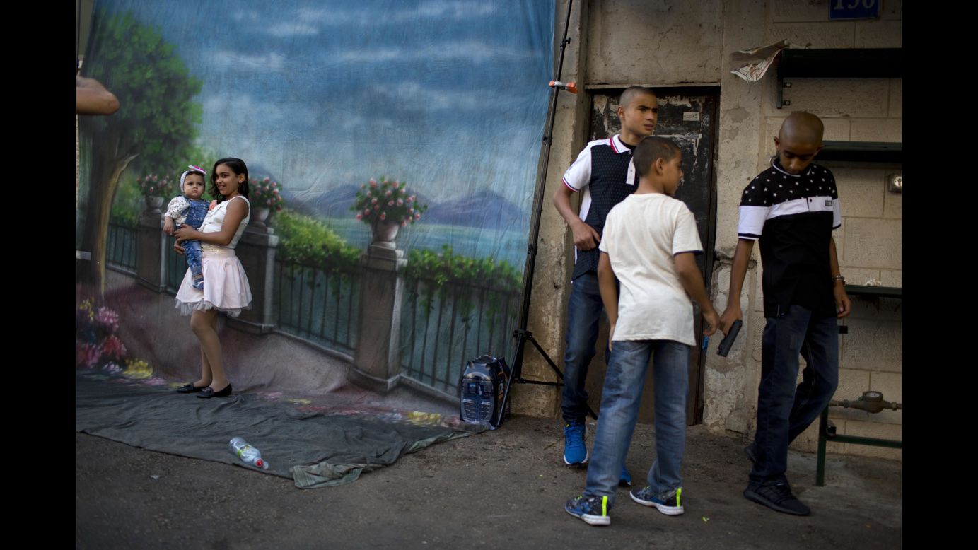 Girls pose for a photo while three boys play with a toy gun during Eid al-Adha in Jaffa, Israel, on Monday, September 12.