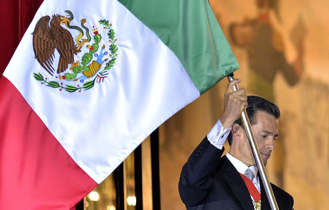 President Enrique Pena Nieto waves the Mexican National Flag.