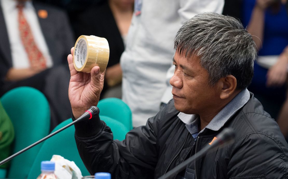 Edgar Matobato holds roll of a packing tape as he testifies during a senate hearing in Manila on September 15, 2016. He said it was used to mask victims' identities.