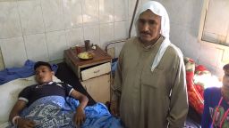 Mahmud Jassim, 16, receives treatment at Aleppo. His  father is by his side.