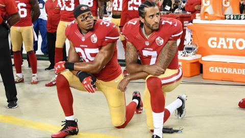 Colin Kaepernick, right, and Eric Reid of the San Francisco 49ers kneel in protest during the National Anthem before playing the Los Angeles Rams on September 12, 2016.
