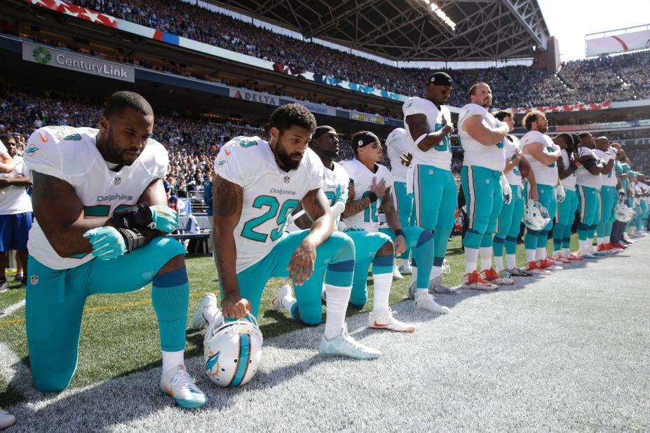From left, Miami Dolphins' Jelani Jenkins, Arian Foster, Michael Thomas and Kenny Stills kneel during the singing of the national anthem before a game against the Seattle Seahawks on September 11, 2016.