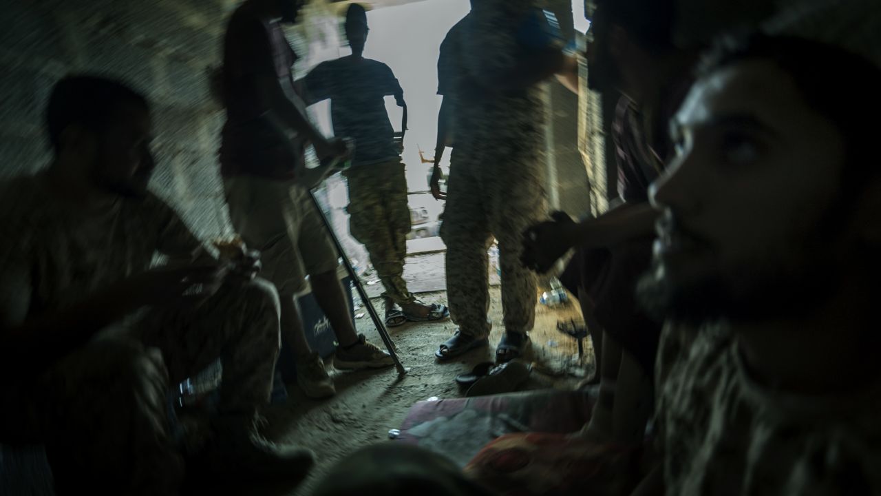 Libyan forces take shelter in a derelict district close to the front line. 