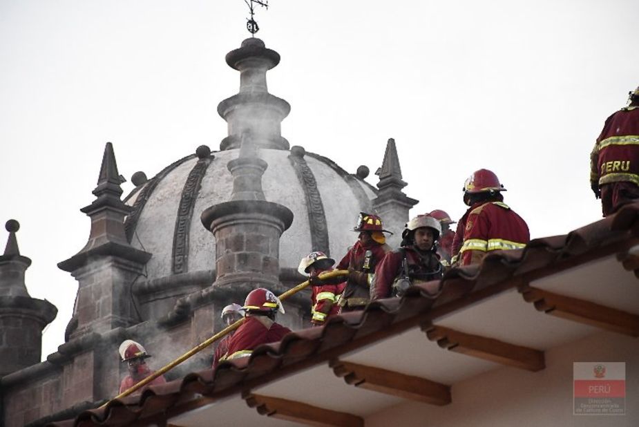 Firefighters check out damage to the roof of San Sebastian Church. The church's roof is in danger of collapsing.