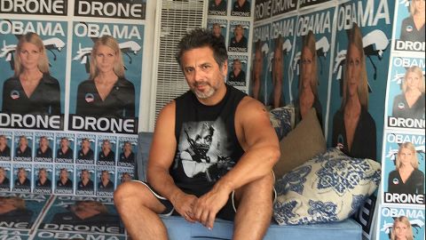 The street artist Sabo rose to the national stage with art that often shocks, offends and confronts some of America's most controversial hot-button issues. Here, he poses in front of posters of actress Gwyneth Paltrow represented as an "Obama drone."