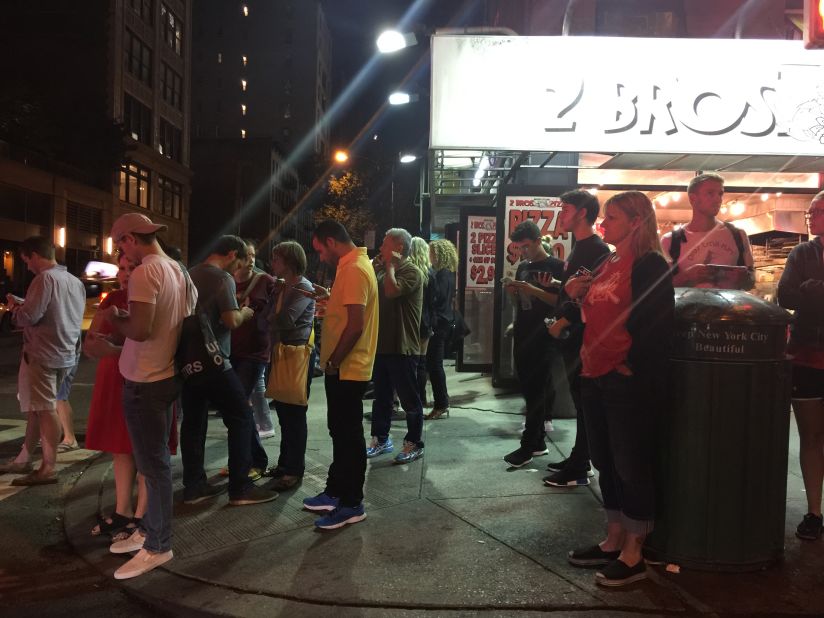 Onlookers gather on the street. 