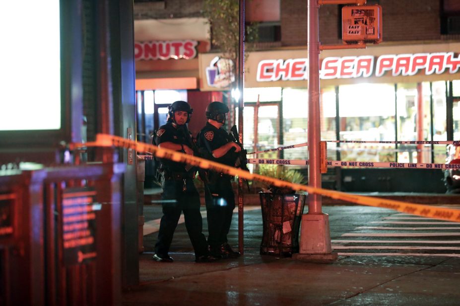 Two heavily armed police officers survey the scene. 