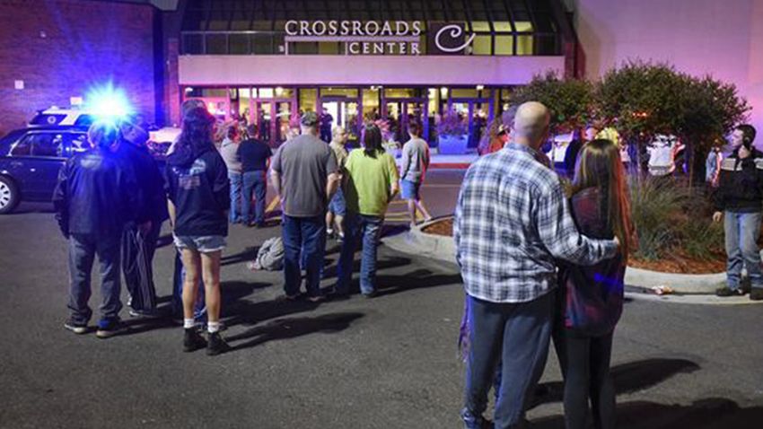 People stand near the entrance on the north side of Crossroads Center mall between Macy's and Target as officials investigate a reported multiple stabbing incident, Saturday, Sept. 17, 2016, in St. Cloud, Minn. Police said multiple people were injured at the St. Cloud shopping mall on Saturday evening in an attack possibly involving both shooting and stabbing. The suspect is believed to be dead, St. Cloud Police Sgt. Jason Burke told the St. Cloud Times. (Dave Schwarz/St. Cloud Times via AP)