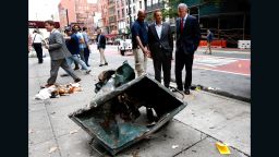 epa05546353 New York Mayor Bill de Blasio (R) and New York Governor Andrew Cuomo (2-R) look over a mangled dumpster while touring the site of an explosion that occurred overnight in the Chelsea neighborhood of New York, New York, USA, 18 September 2016. Over 20 people were injured in blast. The motive is still being investigated, despite authorities assuming it is apparently not linked to international terrorism.  EPA/JUSTIN LANE