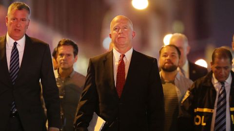 New York Police Commissioner James O'Neill (center) and Mayor Bill de Blasio walk into a press conference as police, firefighters and emergency workers gather at the scene of an explosion in Manhattan on September 17, 2016 in New York City.