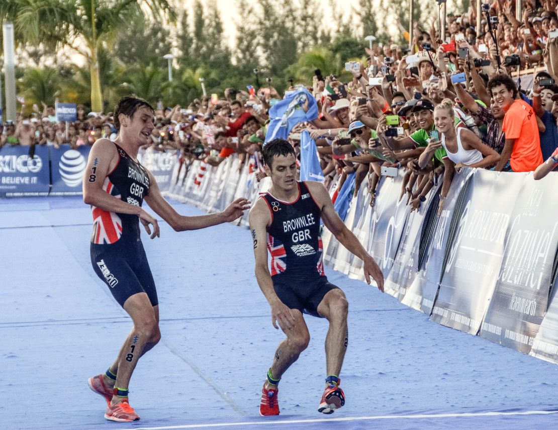 Alistair Brownlee (L) helps his brother Jonny (R) cross the line during the 2016 ITU World Triathlon Championships.