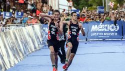 TOPSHOT - British athlete Alistair Brownlee (L) helps his brother Jonathan Brownlee (R) before crossing the line in second and third place during the ITU World Triathlon Championships 2016 in Cozumel, Quintana Roo, Mexico on September 18, 2016. / AFP / ELIZABETH RUIZ        (Photo credit should read ELIZABETH RUIZ/AFP/Getty Images)