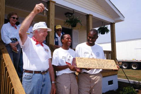 President Jimmy Carter presents Neal and Michele Hughley with the keys to their new Habitat house completed during the Jimmy Carter Work Project in 2000.
