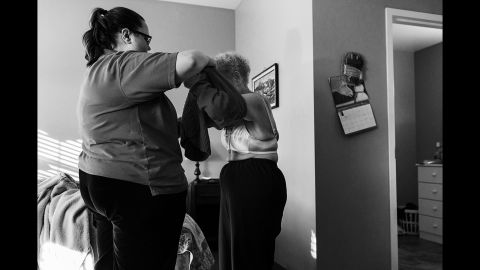 An employee at the memory care facility helps Eloise get dressed.