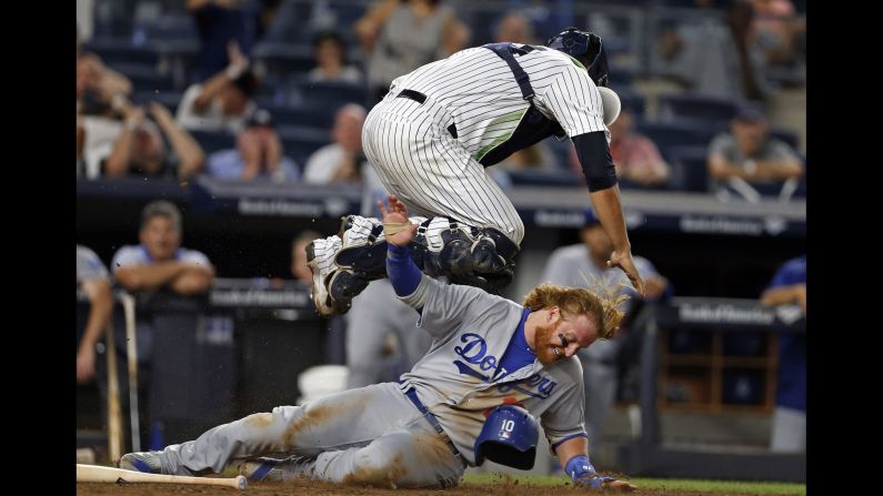 Justin Turner, a third baseman for the Los Angeles Dodgers, scores a run under New York Yankees catcher Gary Sanchez on Wednesday, September 14.