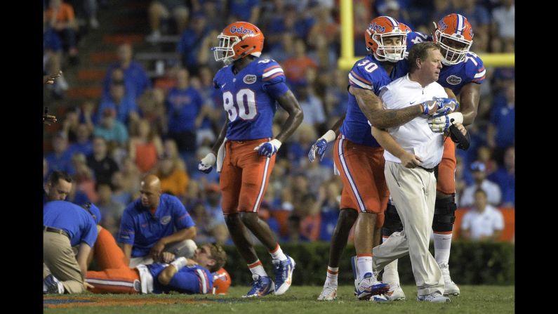 Florida head coach Jim McElwain is restrained by tight end DeAndre Goolsby and offensive lineman Fred Johnson after his quarterback, Luke Del Rio, was injured by a North Texas player on Saturday, September 17. North Texas was penalized for roughing the passer, and McElwain went to midfield to let the North Texas bench know he was not happy with the hit. 