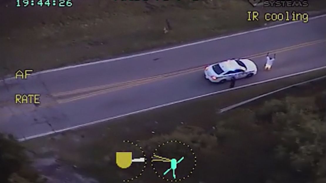 Video from a police helicopter circling above shows Crutcher wit his hands up as an officer approaches him.