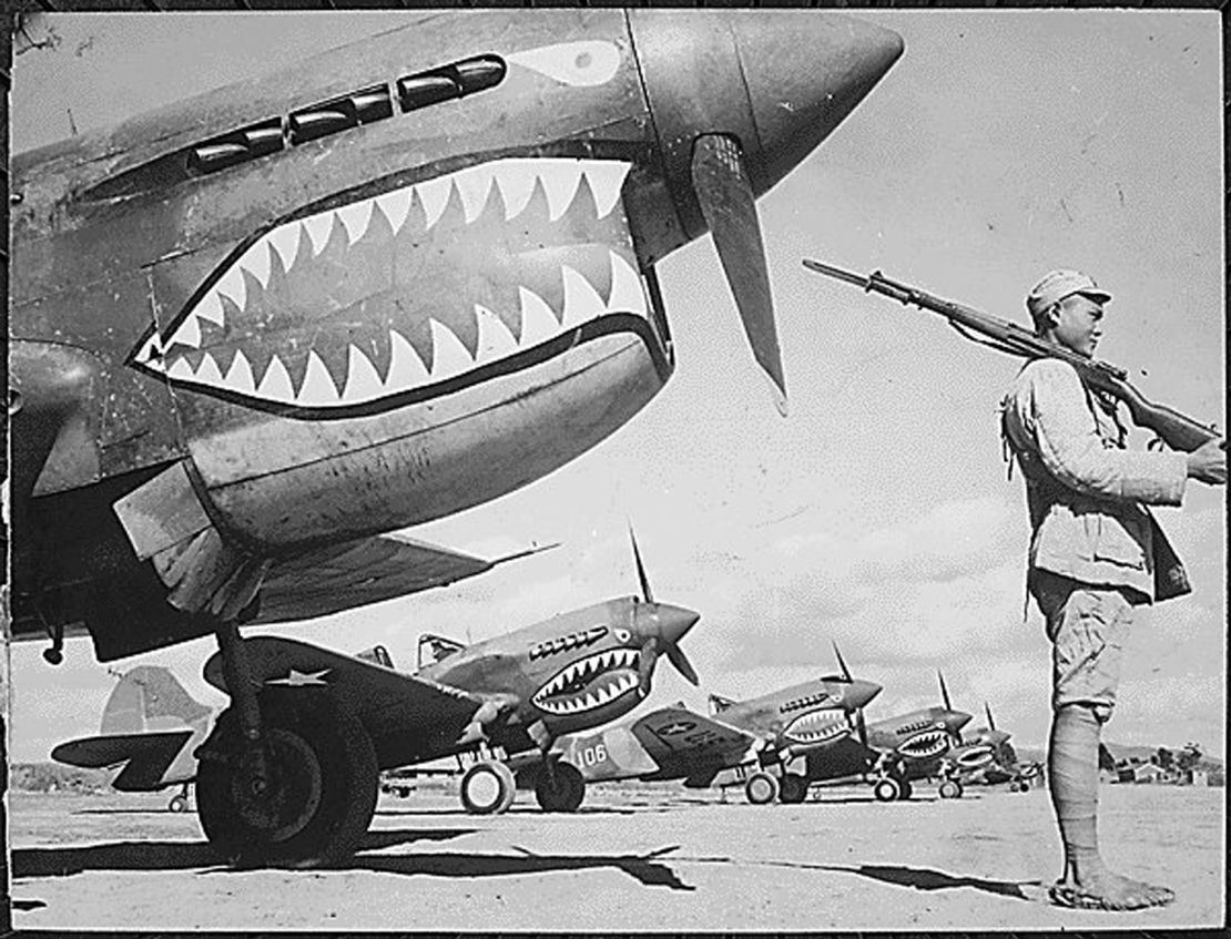 A Chinese soldier guards a line of American P-40 Flying Tiger fighter planes at an airfield somewhere in China.