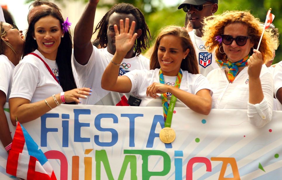 Tennis player Monica Puig waves to the crowd after arriving back in Puerto Rico from the Rio 2016 Olympics, where she became her country's first gold medalist.