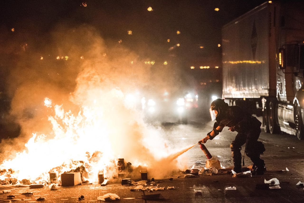 A police officer attempts to extinguish a fire on I-85.