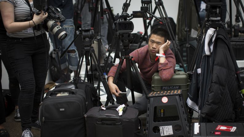 A photographer waits for the Topshop Unique catwalk show on September 18. Jeff Moore, a fashion week veteran of over 20 years, says a typical working day can be at least 15 hours long.