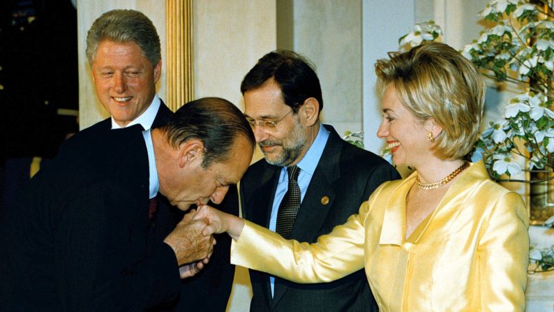 Chirac kisses the hand of U.S. first lady Hillary Clinton at a NATO summit in Washington in 1999.