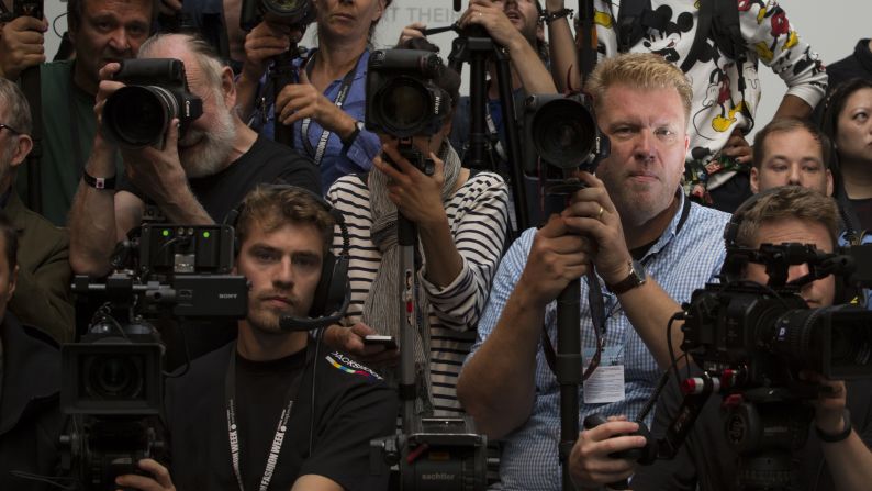 Photographer Jonas Gustavsson (R) poses for a portrait while he waits for the start of the Mary Katrantzou catwalk show on September 18.