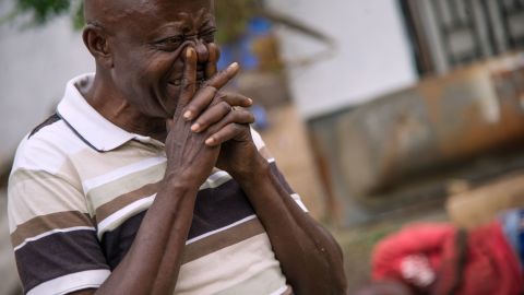 A man cries on September 20, 2016 near the offices of the main opposition Union for Democracy and Social Progress (UDPS) party which were torched overnight and early on September 20, in Kinshasa.