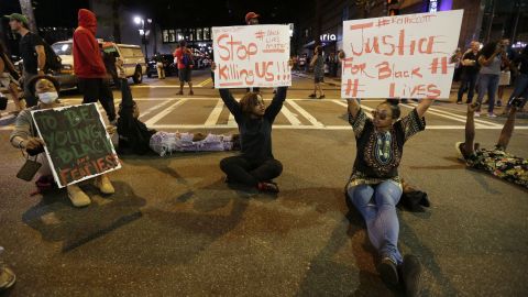 Demonstrators hold Black Lives Matter signs. 