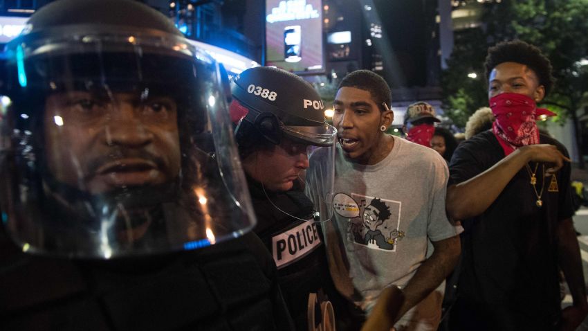Protesters taunt riot police during a demonstration against police brutality in Charlotte, North Carolina, on September 21, 2016, following the shooting of Keith Lamont Scott the previous day.
A protester in Charlotte, North Carolina was fatally shot by a civilian during a second night of unrest after the police killed a black man, officials said. / AFP / NICHOLAS KAMM        (Photo credit should read NICHOLAS KAMM/AFP/Getty Images)