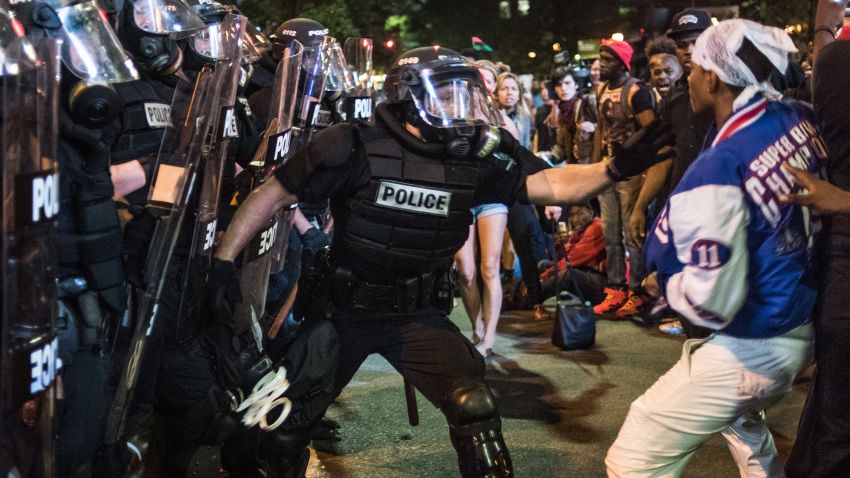 A police officer tries to grab a protester from the crowd.