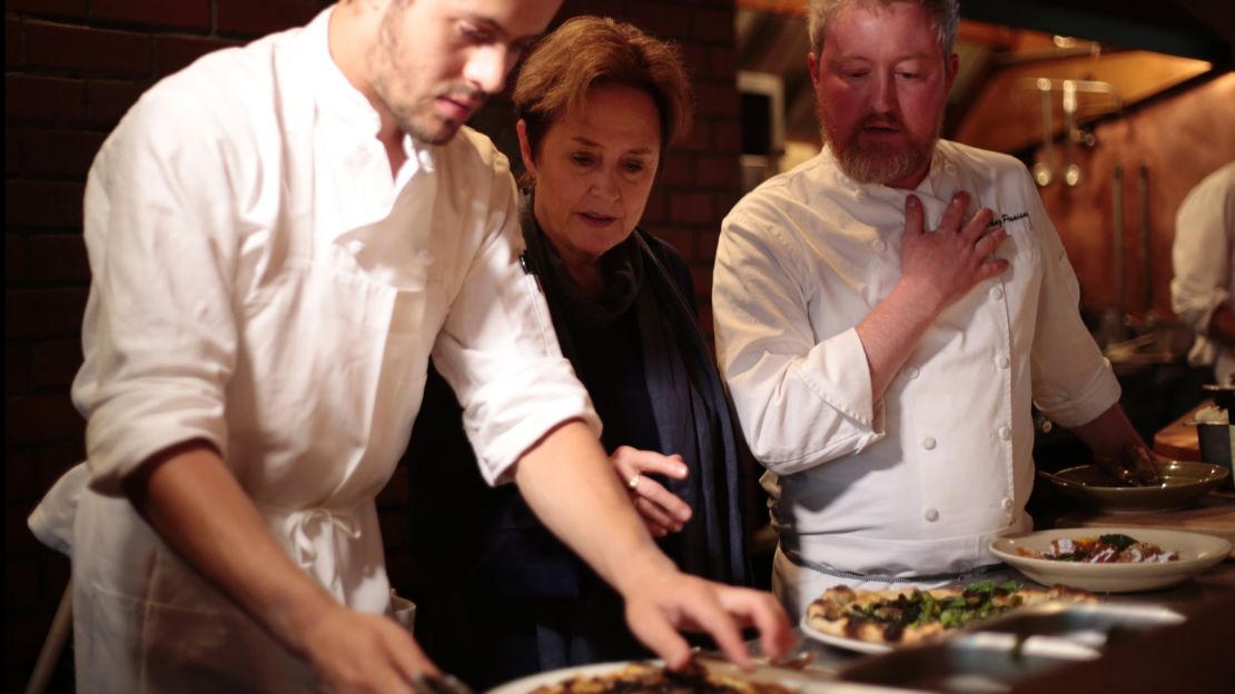 Waters observes as cook Henderson Peternell (left) and cafe chef Nathan Alderson (right) collaborate. 