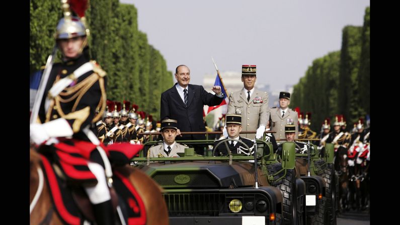 Jacques Chirac waves during a military parade on Bastille Day in Paris in 2006. Chirac survived an assassination attempt when a neo-Nazi gunman fired a rifle at his open-top car during the same annual celebration in 2002.
