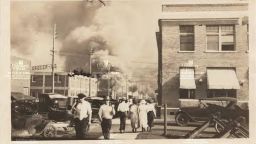 Onlookers watch as a fire erupts during the Tulsa race massacre in 1921.