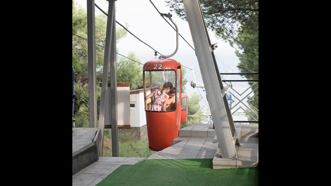 A child rides on a cable car.