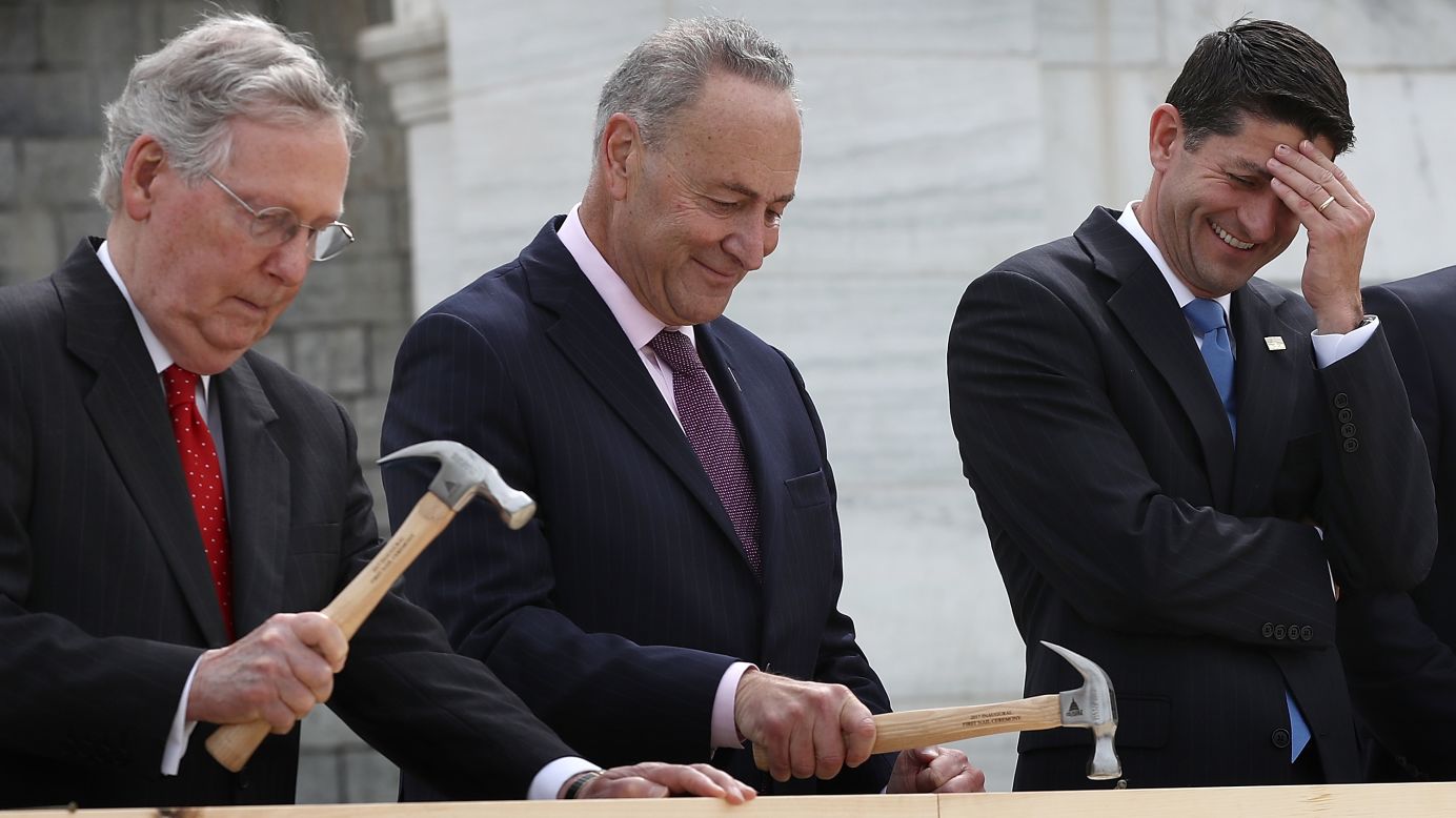 House Speaker Paul Ryan laughs as Senate Majority Leader Mitch McConnell, left, and U.S. Sen. Chuck Schumer hammer ceremonial nails outside the U.S. Capitol on Wednesday, September 21. Construction has begun on the platform where the next President will be inaugurated.