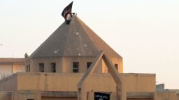 The flag of the Islamic State of Iraq and the Levant (ISIL) flutters on the "dome" of the  Armenian Catholic Church of the Martyrs in the northern rebel-held Syrian city of Raqqa on September 28, 2013.