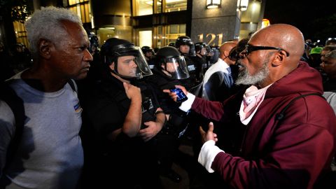 A protester, right, expresses his opinion to a police officer and another pedestrian near Trade and Tryon Streets in Charlotte on Thursday, September 22.
