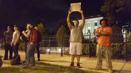 Alex Orange, 26, points a mirror at police Thursday.