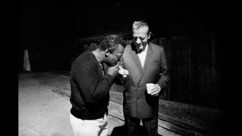 Harry James lights a cigarette for Miles Davis at the Monterey Jazz Festival in 1963.
