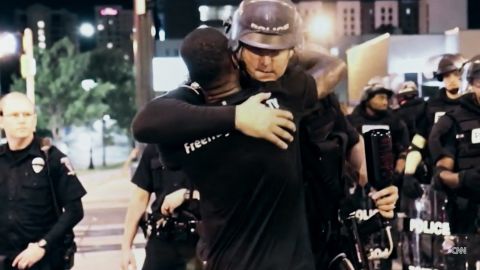 Ken Nwadike hugs an officer in Charlotte on Wednesday night.
