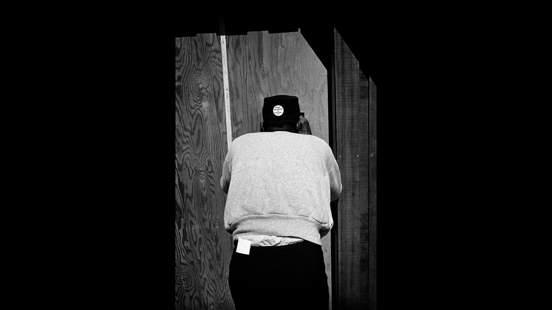 A Dizzy Gillespie fan peeks through a hole backstage at Monterey in 1963. The button on the back of his head says "Dizzy Gillespie for President."