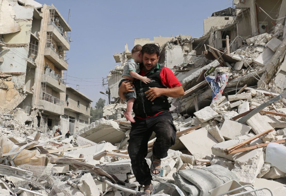A Syrian baby is carried from the rubble following the bombing of a building in Aleppo on Wednesday, September 21. 